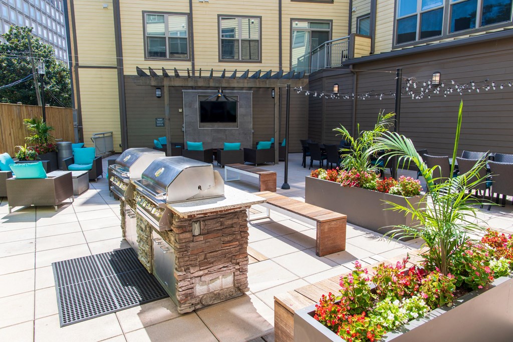 a backyard patio with a grill and a bar