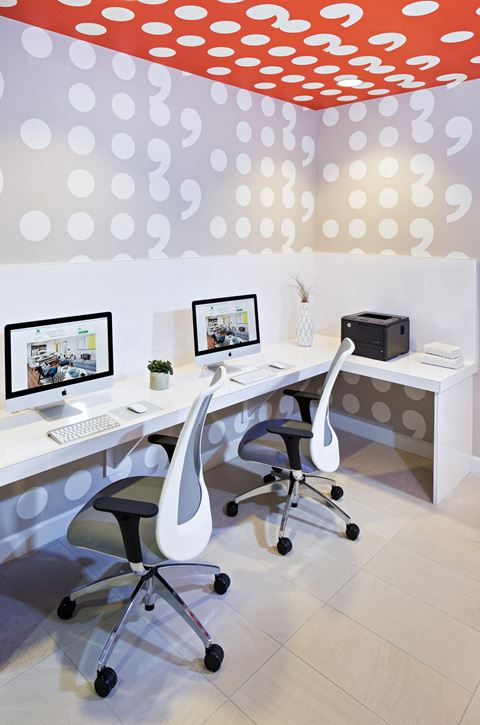 a white office with two computer monitors and two chairs