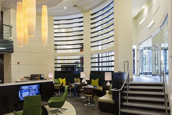 a lobby with chairs and tables and a staircase