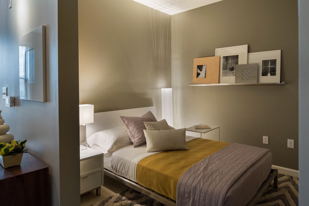 a bedroom with a bed with a yellow blanket and pillows