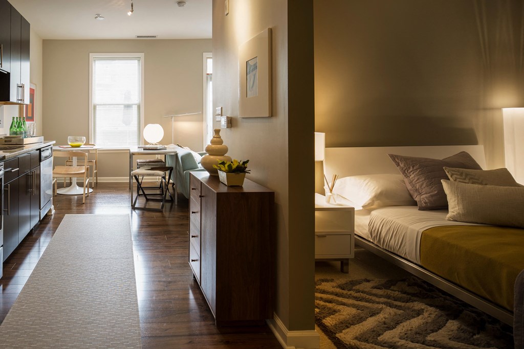 a bedroom with a bed and a living room with a desk