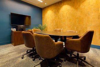 A conference room with a large table and chairs.