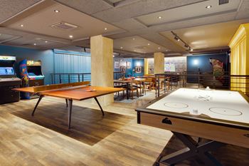 A room with a pool table and a shuffleboard table.