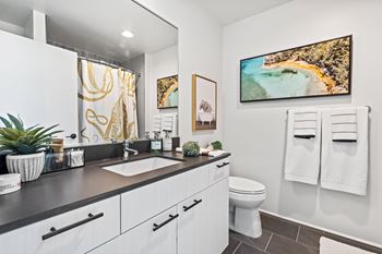 A bathroom with a white toilet and a painting on the wall.