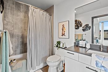 A bathroom with a toilet, sink, and shower curtain.