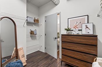 A room with a wooden dresser and a mirror on the left side.