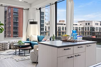 A modern kitchen with a large island and a view of the city.