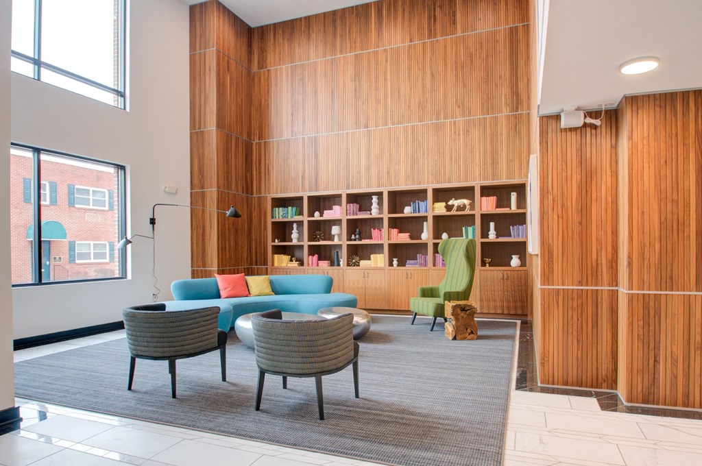 A room with a wooden bookshelf and a grey carpet.