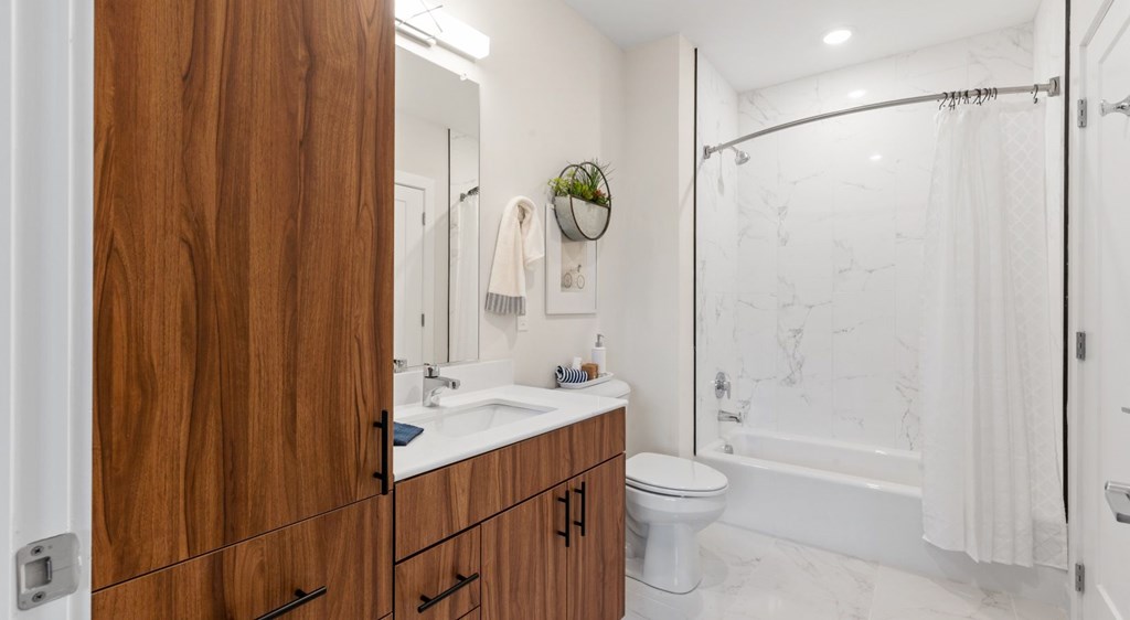 A bathroom with a wooden cabinet and a white toilet.
