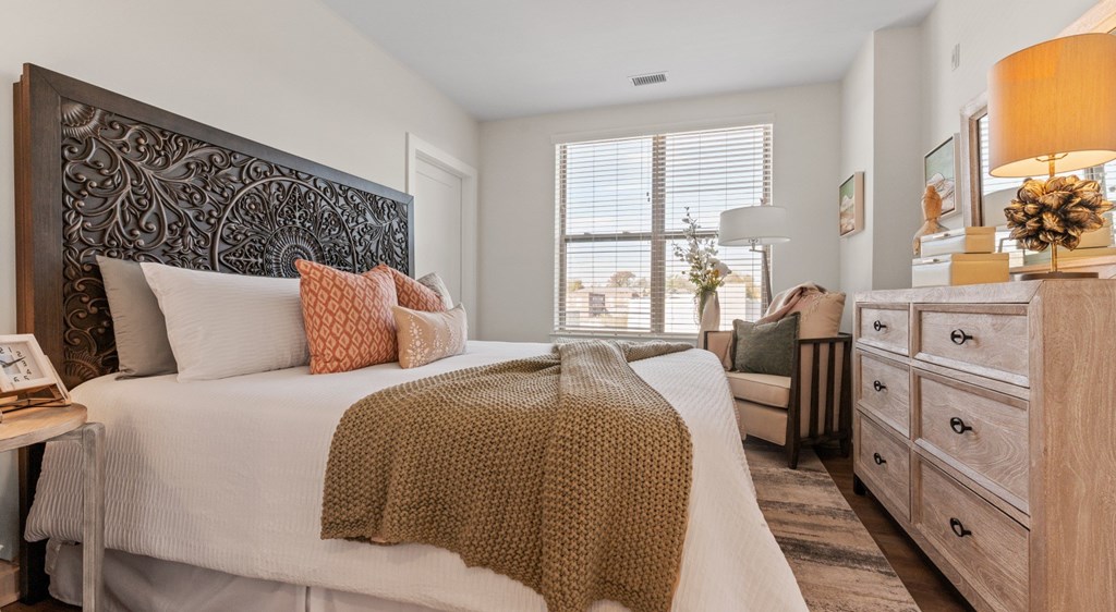 A bedroom with a large bed and a wooden headboard.
