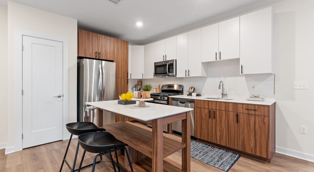 A kitchen with a table and chairs in front of a refrigerator.