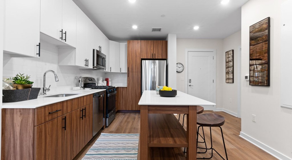 A modern kitchen with wooden cabinets and a white countertop.