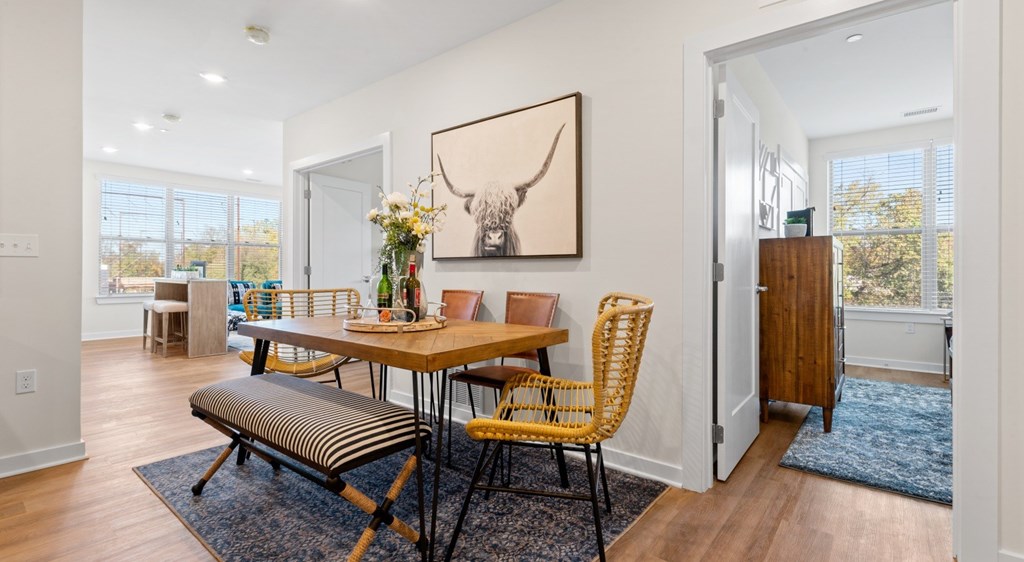 A dining room with a wooden table and chairs.