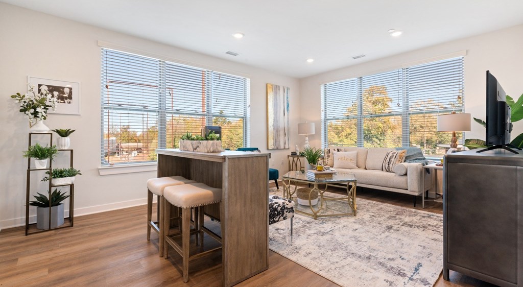 A modern living room with a bar stool and a couch.