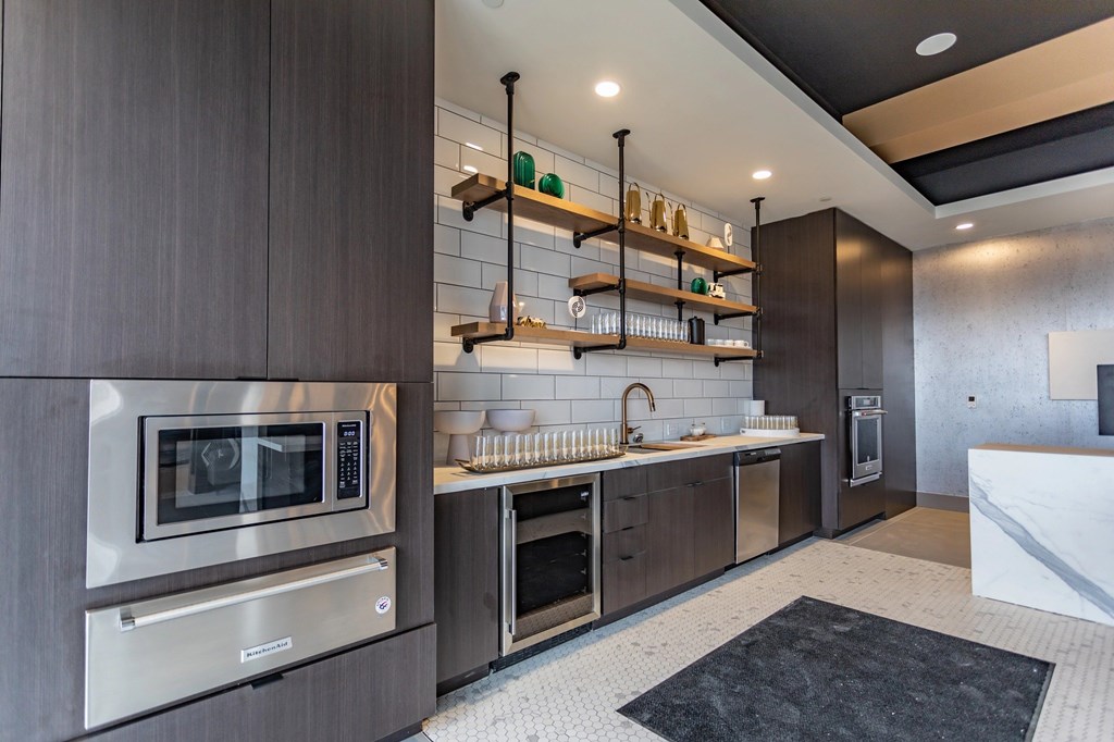 A modern kitchen with dark wood cabinets and stainless steel appliances.
