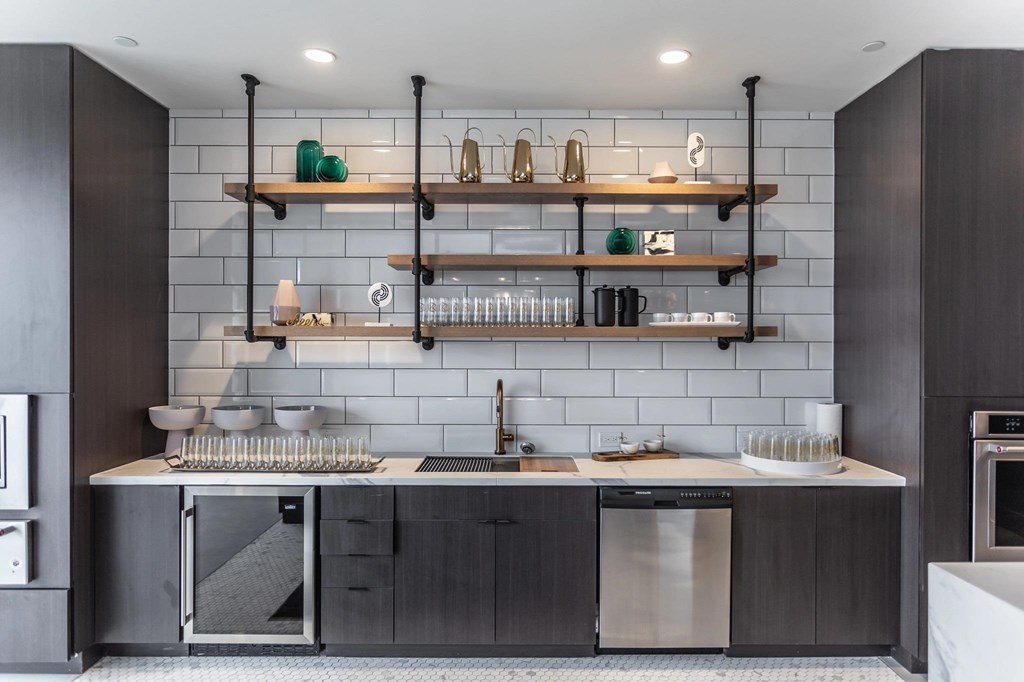 A modern kitchen with dark wood cabinets and a white backsplash.