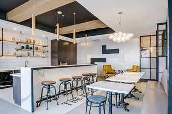 A modern bar with stools and a counter.