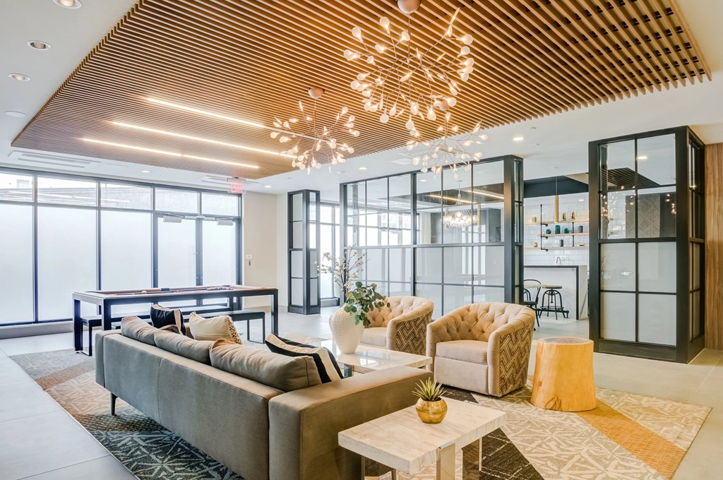 A modern living room with a large sofa and a wooden ceiling.