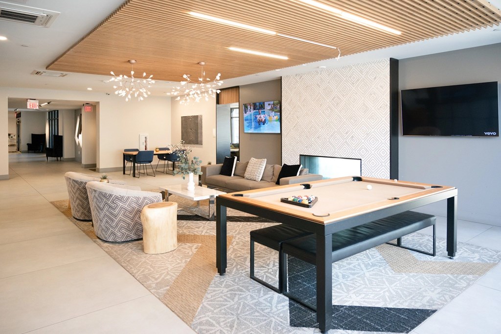 A room with a pool table and a television.