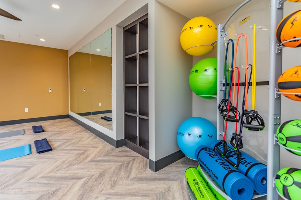A gym with exercise equipment and a mirror.