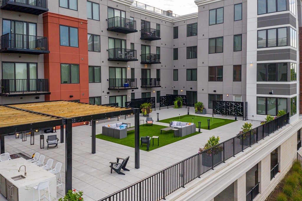 A patio area with a table and chairs is surrounded by apartment buildings.