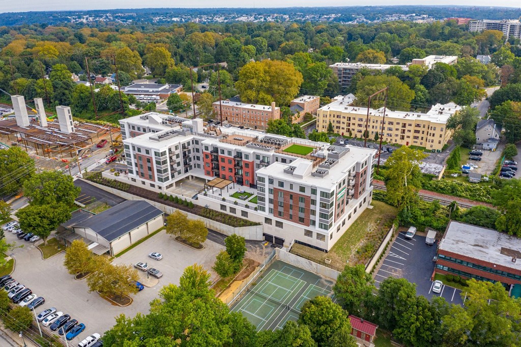 A large building with a tennis court in front of it.
