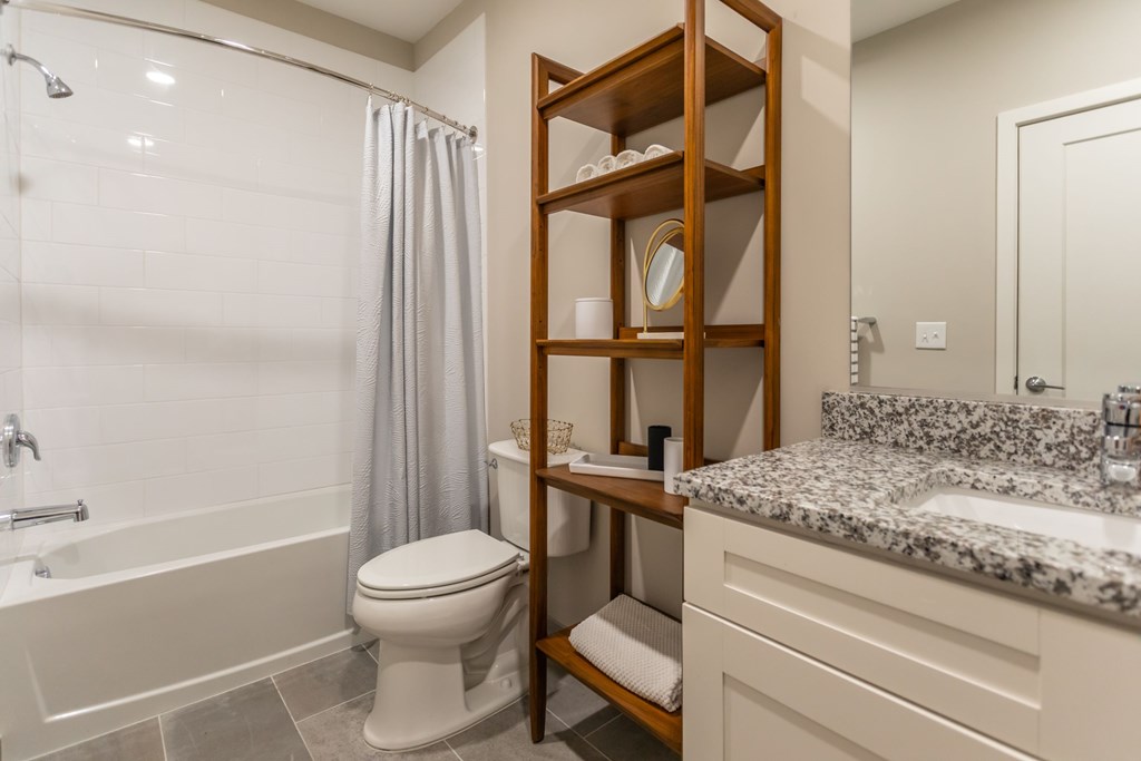 A bathroom with a toilet, sink, and shower.