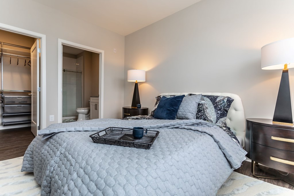 A bedroom with a large bed and a lamp.