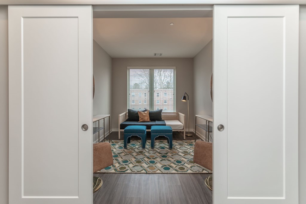 A room with a blue couch and a patterned rug.