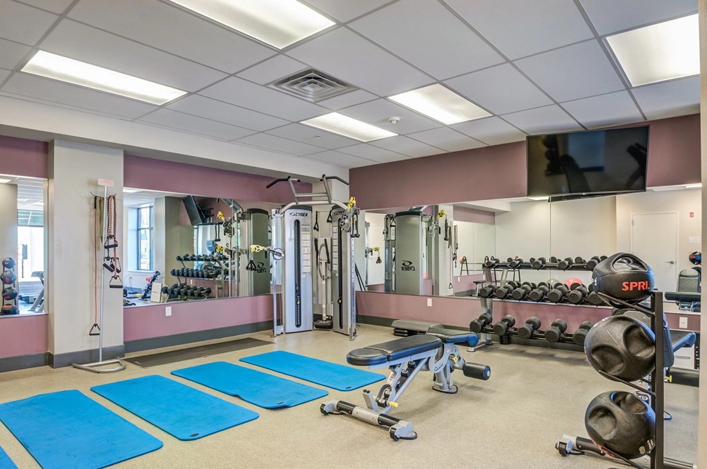 A gym with blue mats on the floor.