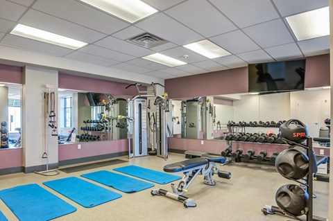 A gym with blue mats on the floor.