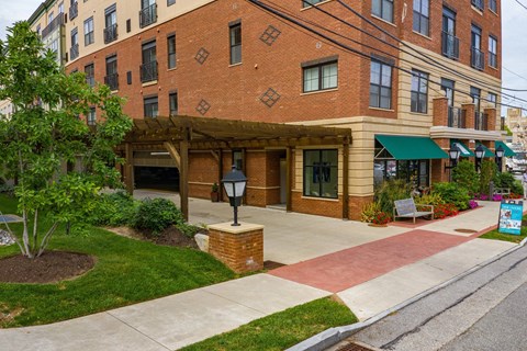 A brick building with a green awning and a lamp post in front.