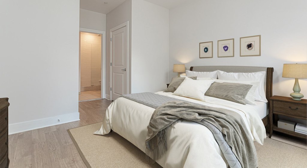 A bedroom with a bed, nightstand, and lamp.