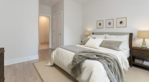 A bedroom with a bed, nightstand, and lamp.