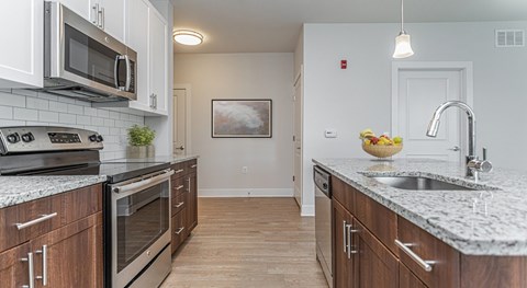 A kitchen with wooden cabinets and granite countertops.