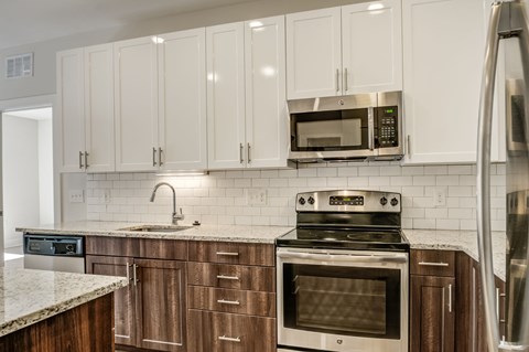 A kitchen with a stove, oven, microwave, and refrigerator.