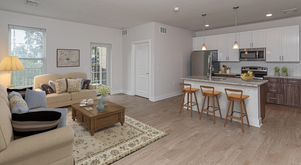 A well-lit, modern kitchen with a breakfast bar and a living room area with a sofa and coffee table.