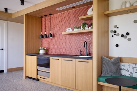 A kitchen with wooden cabinets and a red backsplash.
