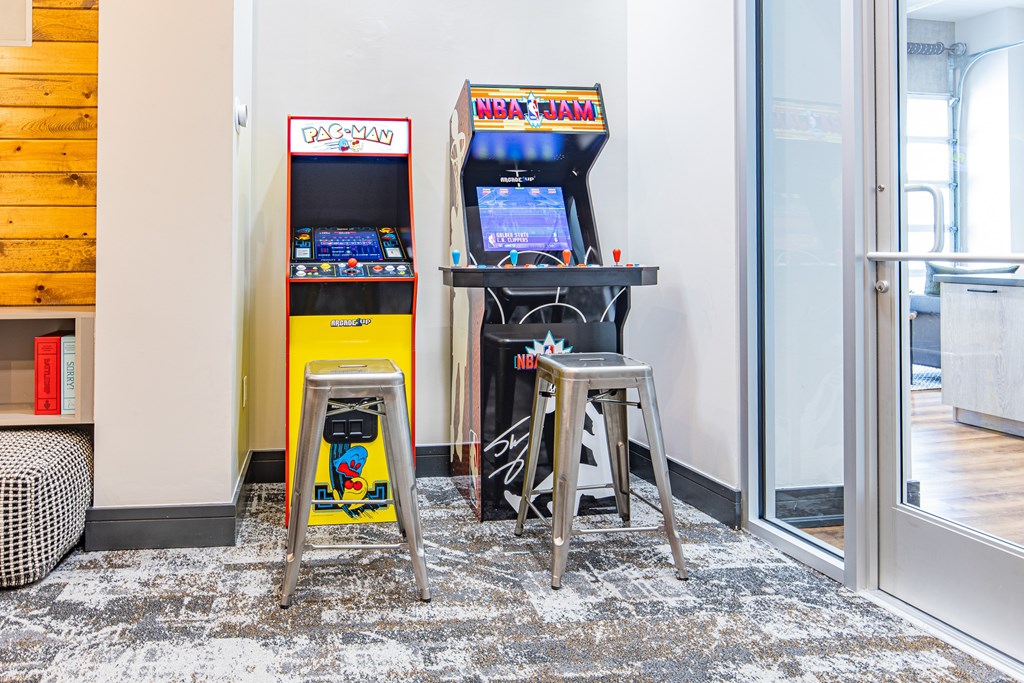 A small arcade game machine sits on a stand in a room.