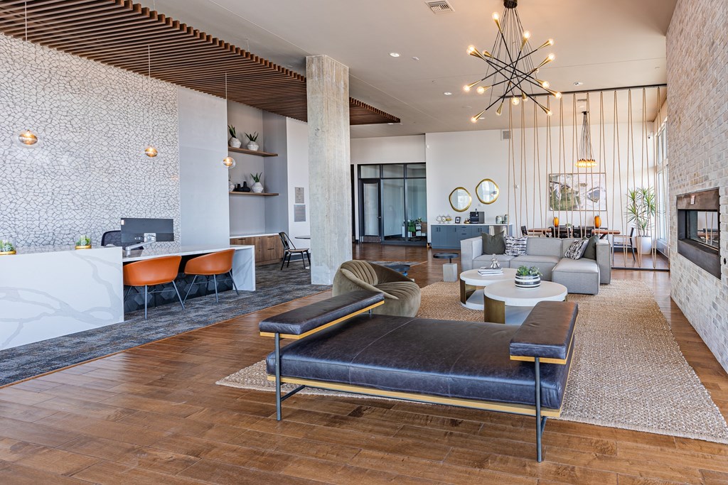 A modern living room with a black sofa and wooden floors.