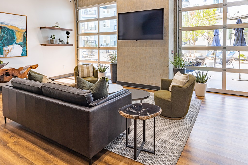 A living room with a grey sofa, a green armchair, and a television.