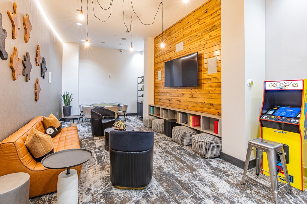 A room with a yellow couch, a TV, and a yellow arcade machine.