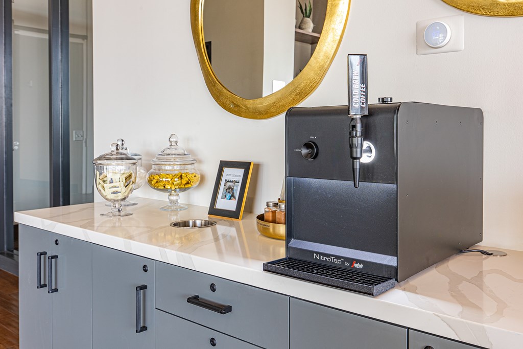 A coffee machine sits on a countertop next to a coffee grinder.