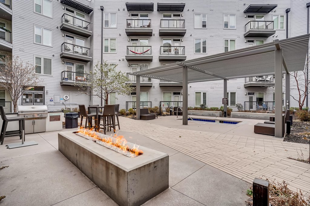 A fire pit sits in the middle of a patio area.