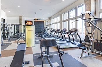 A gym with treadmills, elliptical machines, and other exercise equipment.