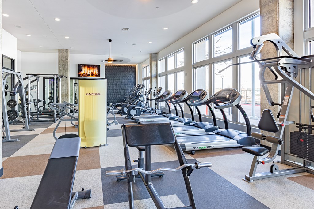A gym with treadmills, elliptical machines, and other exercise equipment.