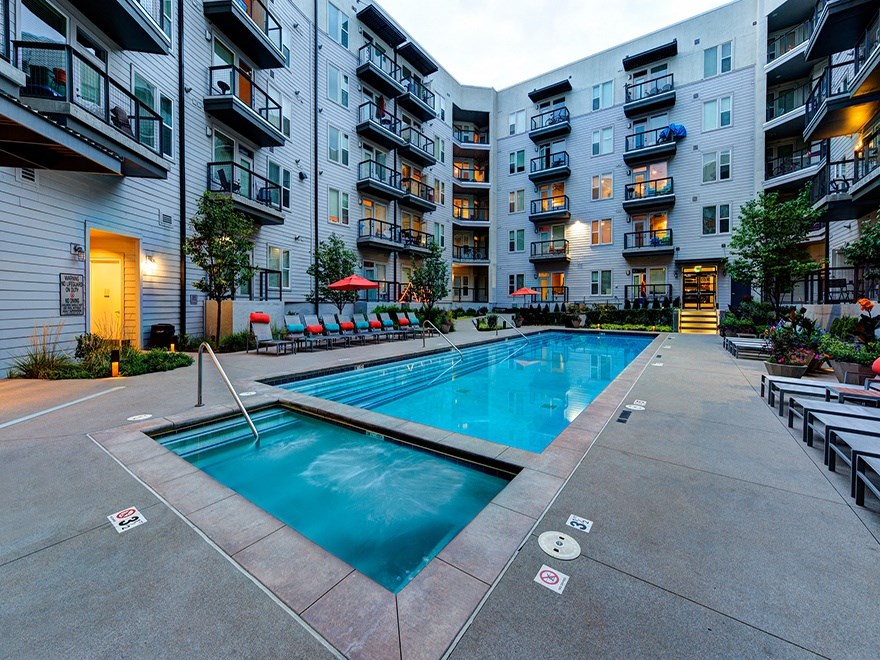 A large swimming pool in front of apartment buildings.