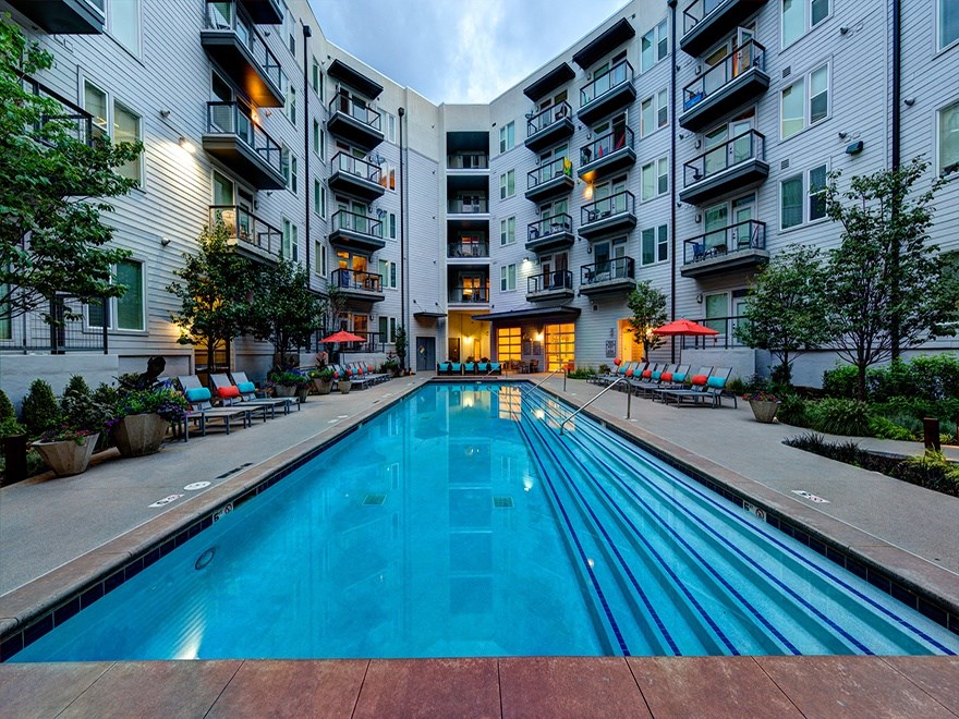 A swimming pool in front of apartment buildings.