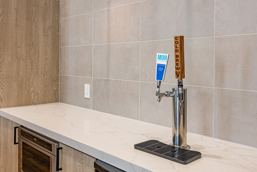 A beer tap with a wooden handle is on a marble countertop.