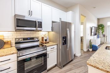 A modern kitchen with stainless steel appliances and white cabinets.